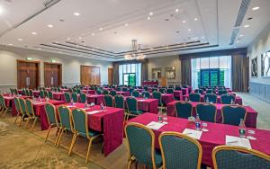 戈曼斯顿城北会议中心酒店的一间会议室,配有桌椅和粉红色的桌布