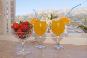 科尔丘拉Guest House Holiday的三杯橙汁和一碗草莓