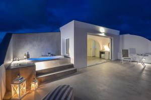 纳克索乔拉圣瓦拉西斯酒店的带浴缸的别墅和夜间天井。