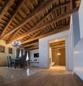 威尼斯San Marco Luxury apartments Muneghe的一间带木制天花板的客厅和一间餐厅