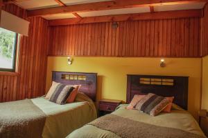 卡斯特鲁帕拉菲托斯渔村度假屋的木镶板客房内的两张床