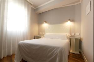 坎德莱达卡斯塔罗斯旅馆的卧室配有白色的床和窗户。