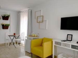 波尔图Koka's Studio的客厅配有黄色椅子和电视