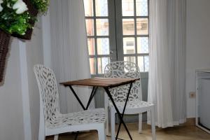 波尔图Koka's Studio的窗户间配有一张桌子和两把椅子