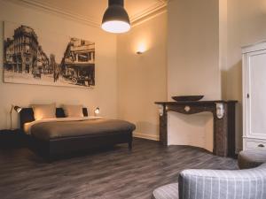 根特Maison Willem Tell的一间卧室配有一张床、一个壁炉和一张沙发