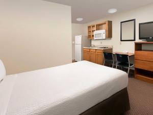 贝尔维尤WoodSpring Suites Omaha Bellevue, an Extended Stay Hotel的酒店客房带一张床和一个厨房