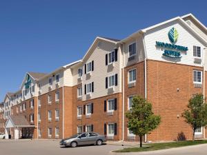 贝尔维尤WoodSpring Suites Omaha Bellevue, an Extended Stay Hotel的前面有停车位的建筑