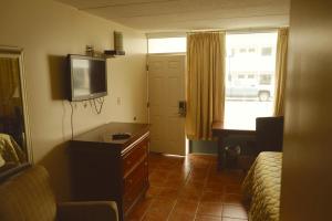 大洋城大洋城海湾汽车旅馆的酒店客房设有一张床、一台电视和梳妆台