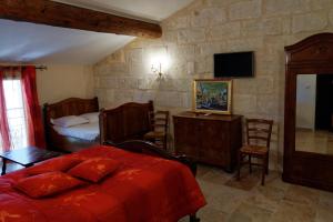 阿尔勒勒马斯德艾斯纳德旅馆的一间卧室配有一张床、一张书桌和一台电视。