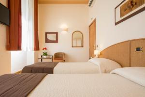 锡耶纳帕拉迪索广场住宿旅馆的酒店客房,配有两张床和椅子
