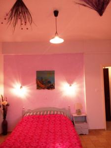 斯基亚索斯镇Skiathos city views studios-apartments的一间卧室配有一张粉红色墙壁的床