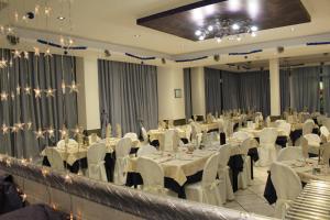 里米尼玛格丽特酒店的宴会厅配有白色的桌子和白色的椅子