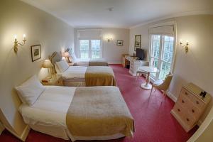 纽伯里Donnington Grove的酒店客房配有两张床和一张书桌