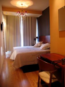 卡斯特罗卡尔德拉斯卡尔德拉斯之家酒店的一间卧室配有一张大床和一张桌子