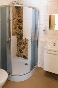 维尔纽斯财神旅馆 的浴室里设有玻璃门淋浴