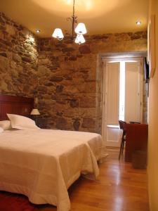 卡斯特罗卡尔德拉斯卡尔德拉斯之家酒店的一间卧室设有一张床和石墙