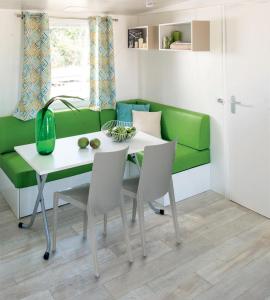 奥尔贝泰洛Giannella Camping的客厅配有绿色沙发、桌子和椅子