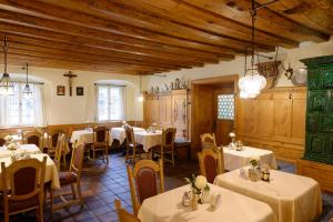 奥巴拉马高阿尔特普斯特酒店的餐厅设有白色的桌椅和木制天花板。
