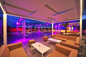比内法尔比内法尔城市Spa酒店的一间设有沙发和紫色灯光舞台的房间