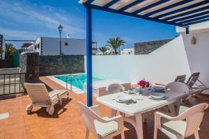普拉亚布兰卡Villa Aitonita的一个带桌椅的庭院和一个游泳池