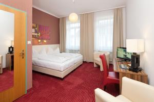 圣珀尔滕豪泽尔厄克城市酒店的酒店客房设有白色的床和电视。