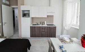 的里雅斯特DOMO Apartments - Trieste Goldoni的小厨房配有白色橱柜和水槽