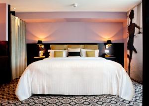 绍斯波特The Vincent Hotel的卧室配有一张白色大床和两盏灯。