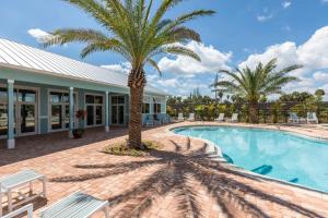 Merritt IslandCape Crossing Resort & Marina的一座游泳池,旁边是一座棕榈树