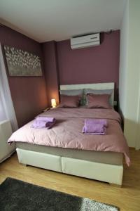 萨格勒布Apartment Mavero-Free Private Parking的一间卧室配有一张带紫色枕头的大床
