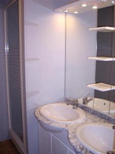 Mansigné拉铁勒斯奥立威酒店的白色的浴室设有2个盥洗盆和淋浴。
