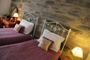 波特马多克Yr Hen Fecws的酒店客房设有两张床和石墙。