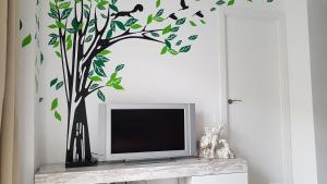 瓦伦西亚Apartamento Jardín de Ayora的一间有鸟的树的房间里设有电视