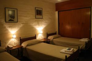 罗卡将军市Hotel La Fundacion的酒店客房设有两张床和两盏灯。