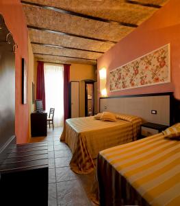 莱西纳B&B Liu' Palazzo Ducale的酒店客房设有两张床和窗户。