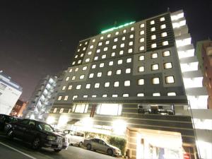 熊本县厅前绿色饭店的一座大型建筑,前面有汽车停放