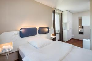 克洛滕迎宾酒店的一间带白色大床的卧室和一间浴室