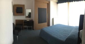 Albino瓦莱多奥尔酒店的一间带一张床和一张书桌的卧室和一间厨房