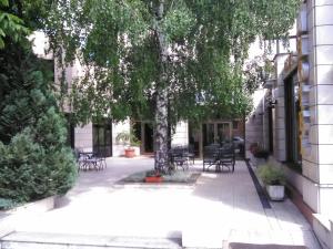 利夫诺迪纳拉酒店的庭院配有桌椅和一棵树