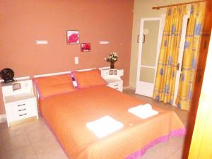 阿尔米罗斯海滩Villa Anna的一间卧室配有一张带橙色床单的大床