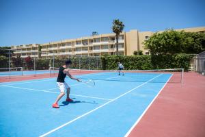伊利索斯阳光罗德岛酒店的两名男子在网球场打网球