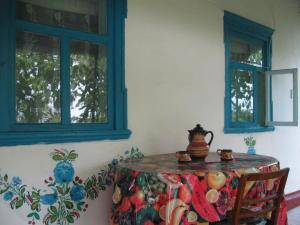 DmitrenkiKалиновий Kущ的一间带桌子和2个窗户的用餐室