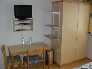 绍萨尔地区基策克Haus Renarth - Michaela Pro的客房设有桌子、电视、小桌子和椅子。