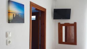 普里诺斯Rooms Ntontas的一间设有镜子和墙上电视的房间