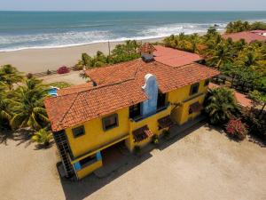 波乔米尔Solyar Luxury Spanish Beachfront Home的海滩上一座黄色房子,屋顶红色