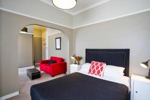 肯图巴卡通巴酒店的一间卧室配有一张床和一张红色椅子