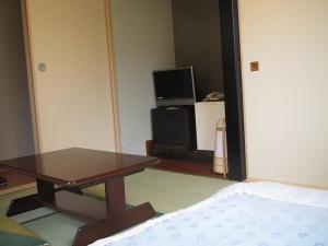 东京富士旅馆的客厅配有桌子和电视