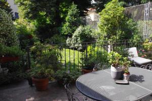 米兰特奥多拉住宿加早餐旅馆的庭院配有桌椅和植物