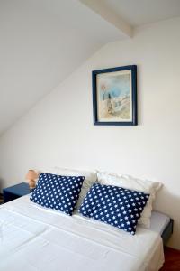 斯普利特Rooms Lux的白色的沙发,上面有蓝色和白色的枕头