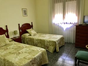 卡尔多纳维沃里旅馆的一间卧室设有两张床、一台电视和一扇窗户。