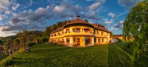 Eberstein凯旋门生态乡村酒店的绿色田野上的大型黄色房屋